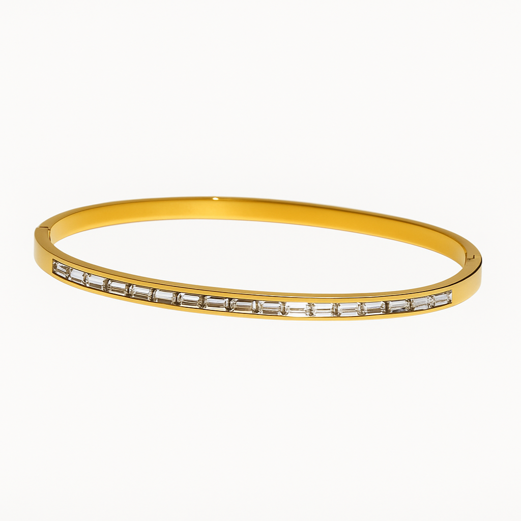 Gold bangle with embedded stones on a white background