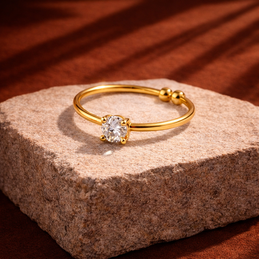 Gold ring with a diamond on a stone surface