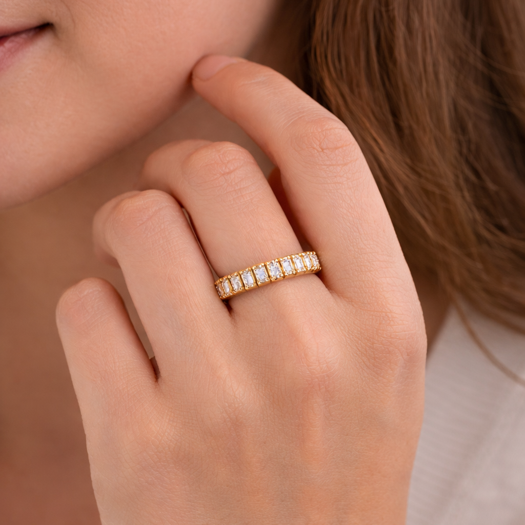 Close-up of a hand wearing a gold ring with a blurred background