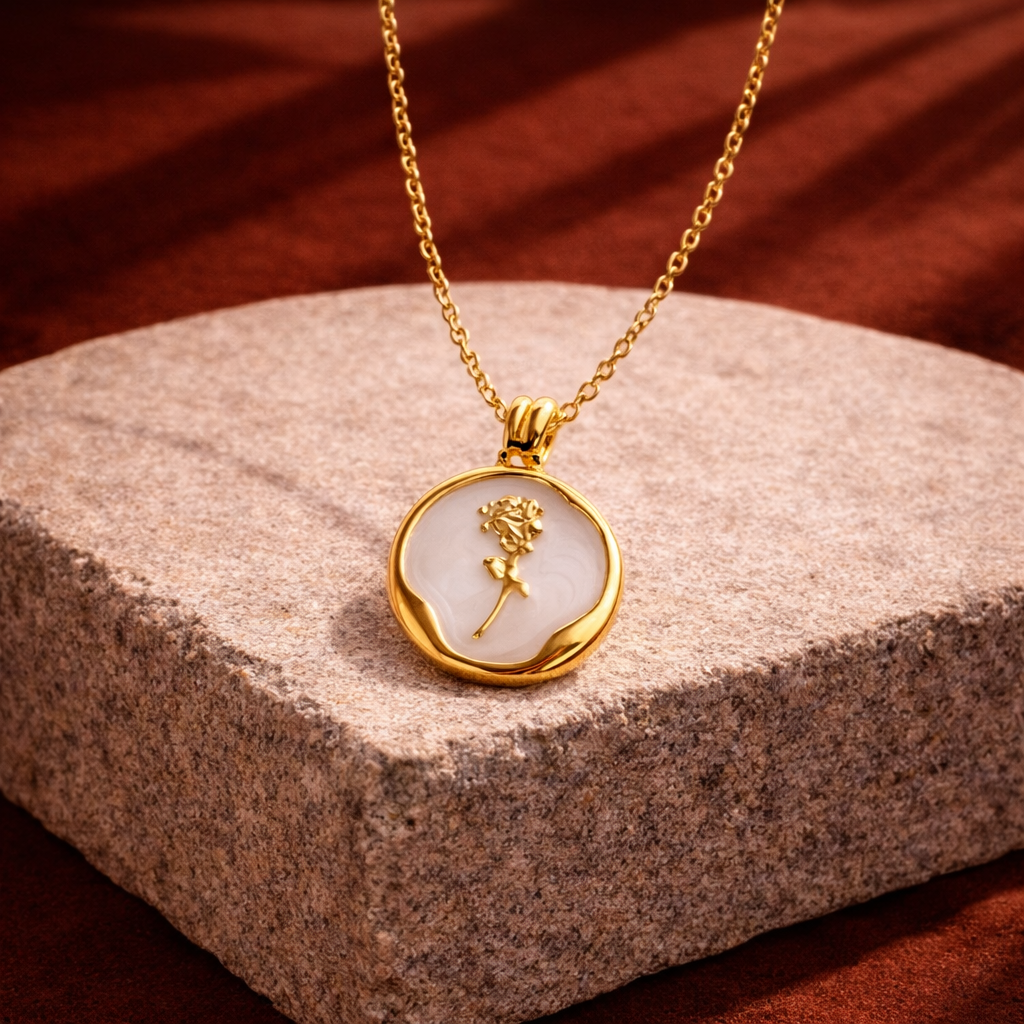 Gold necklace with a pendant on a stone surface