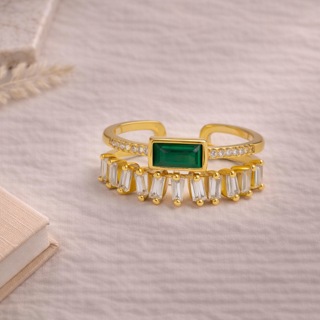 Gold ring with a green gemstone on a textured surface