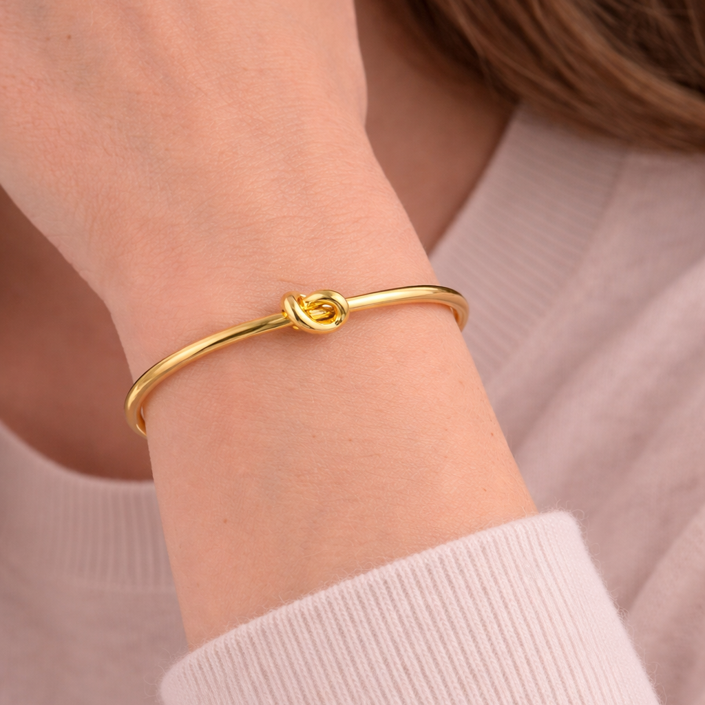Gold bracelet on a person's wrist with a blurred background
