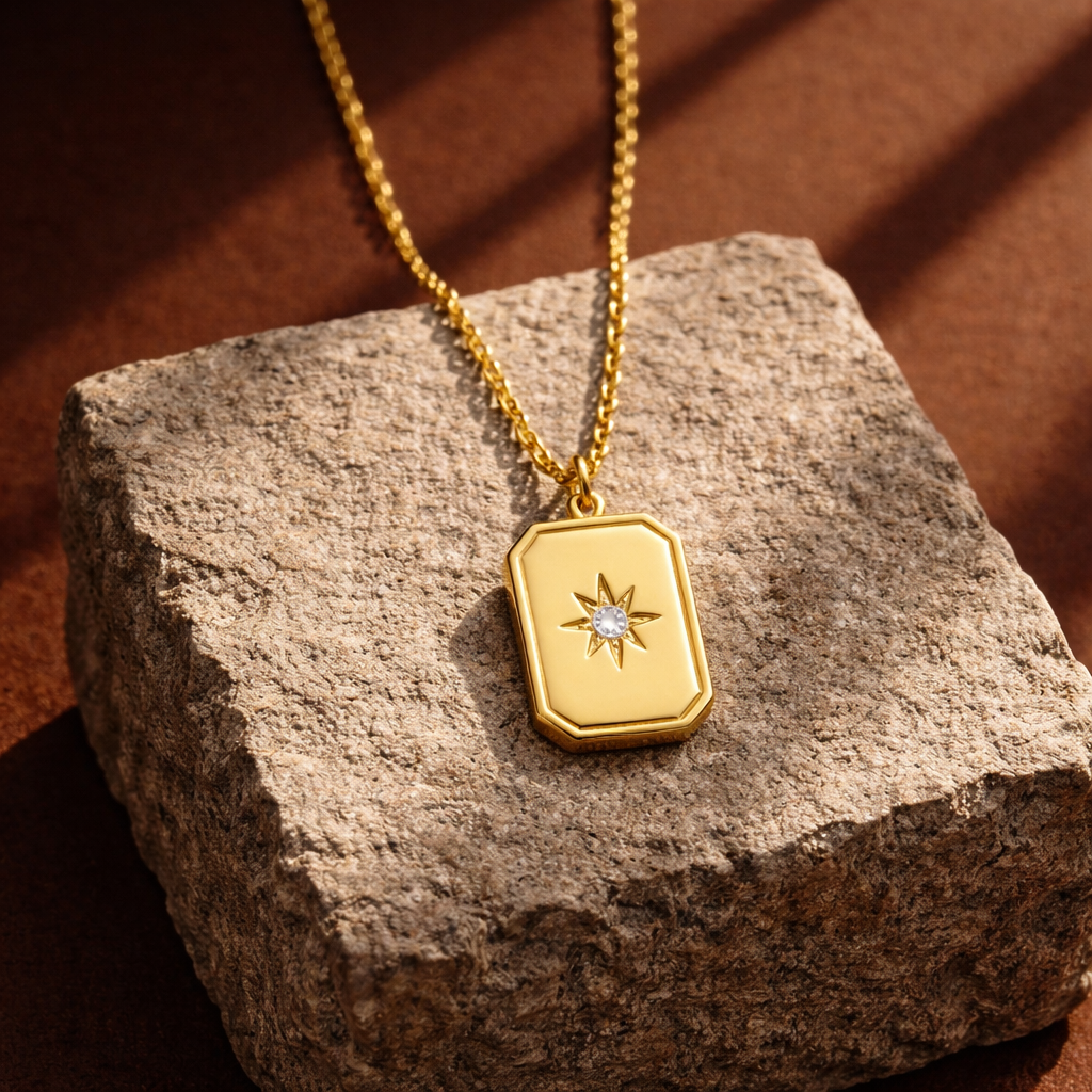 Gold necklace with a pendant on a textured stone surface