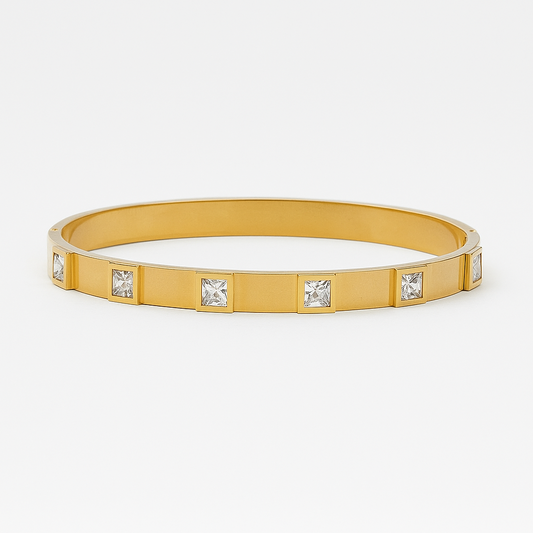 Gold bracelet with embedded crystals on a white background