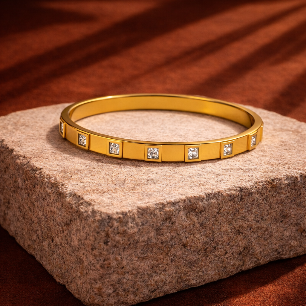 Gold bracelet with embedded diamonds on a stone surface