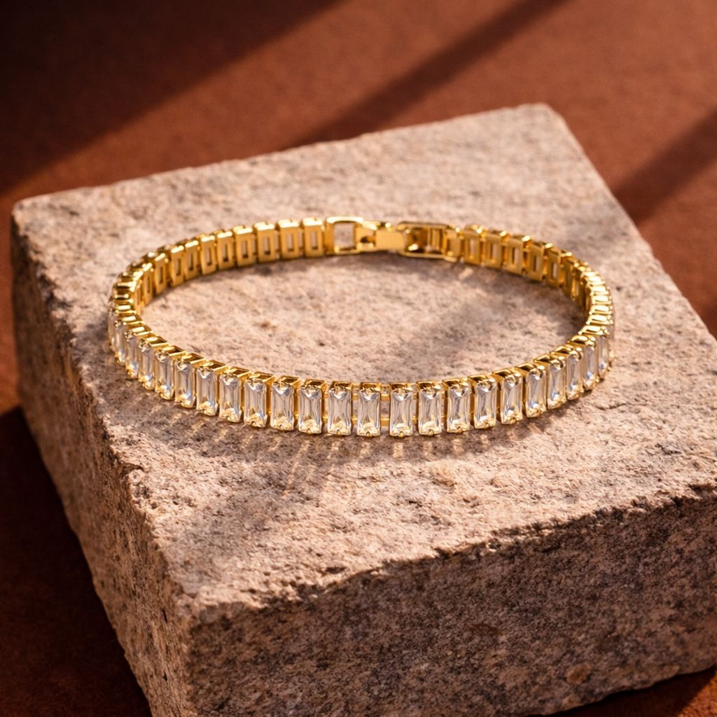 Gold bracelet with clear stones on a textured stone surface